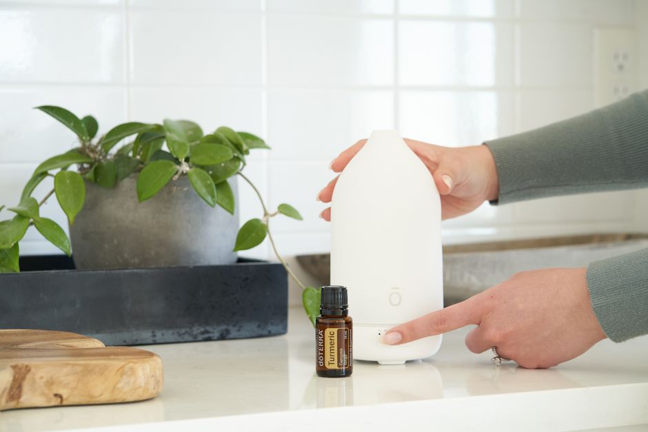 Flesje etherische olie naast diffuser. Flesje etherische olie naast diffuser.